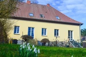 żółty dom z czerwonym dachem w obiekcie Gutshaus Neu Necheln w mieście Brüel