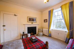 a bedroom with a bed and a fireplace at Dunfallandy House Hotel in Pitlochry