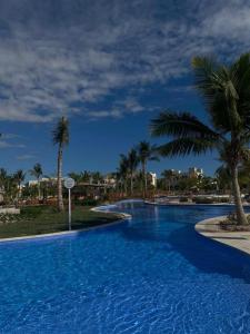 a large swimming pool with palm trees in a resort at Amazing Apartment in Salalah