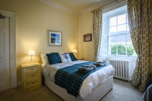 a bedroom with a bed and a window at Dunfallandy House Hotel in Pitlochry