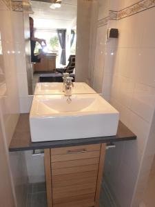 ein Badezimmer mit einem weißen Waschbecken und einem Spiegel in der Unterkunft Studio Village Naturiste Purple & Angel in Cap d'Agde