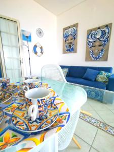sala de estar con mesa de cristal y sofá azul en Appartamento in riva al mare, en Trabia
