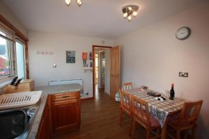 een keuken met een tafel en stoelen en een keuken met een wastafel bij Ferienhaus für 4 Personen ca 90 qm in Plasterfield, Schottland Hebriden in Stornoway