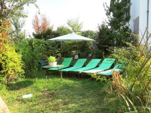 a table and chairs with an umbrella in the grass at Apartment Carroccio Giallo by Interhome in San Damiano dʼAsti