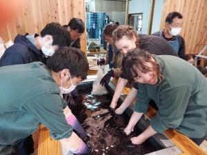 a group of people in a room looking at a stream of water at PAYSAGE MORIGUCHI in Mima