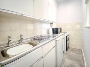 a small kitchen with a sink and a microwave at Apartment 2 - 1 Bedroom Sea Front-Sea Views-Free Parking in Paignton +10 photos