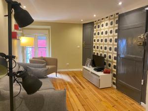 a living room with a couch and a television at Alfama Downtown Apartments in Lisbon