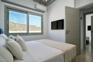 - une chambre blanche avec un lit et une fenêtre dans l'établissement Destiny Villa, à Psarrou