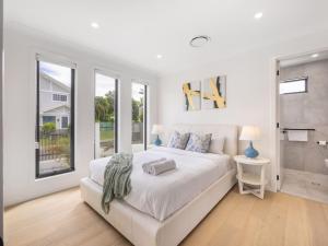 Un dormitorio blanco con una cama grande y una ventana en Prestige and Elegance 5BR House w Pool Rochedale, en Rochedale