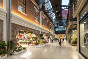 Una mujer caminando por un centro comercial con flores en Charming 3BR Inner City Haven Highgate Hill, en Brisbane