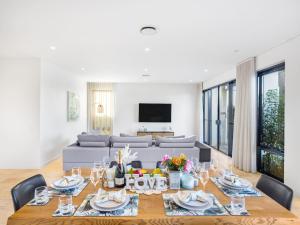 a living room with a table and a couch at Luxurious 4BR Waterfront Retreat in Mermaid Waters in Gold Coast