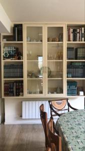 a white cabinet with glass doors with books on it at Piscina climatizada todo el año in Valle