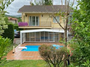 a house with a swimming pool in front of a house at Piscina climatizada todo el año in Valle