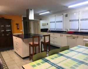 a kitchen with white cabinets and a table and chairs at Piscina climatizada todo el año in Valle