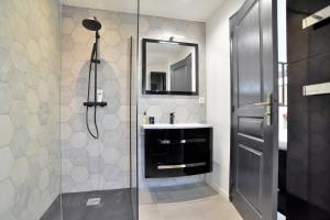 a bathroom with a shower with a sink and a mirror at La Saleya - Maison à moins d'un km de la plage in Dinard +16 photos