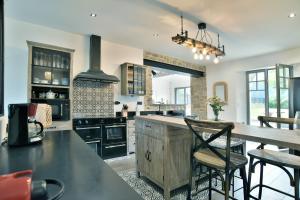 a kitchen with a table and chairs and a stove at La Saleya - Maison à moins d'un km de la plage in Dinard