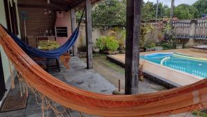 Casa com piscina em 6 min a pé da praia de Jaconé في ماريكا: أرجوحة على فناء بجوار حمام السباحة