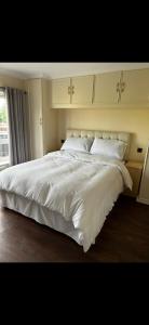 a large white bed in a bedroom with a window at Badgers rest lodge in Kinlet
