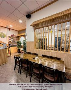 uma sala de jantar com uma grande mesa de madeira e cadeiras em Hồng Châu Hotel em Da Nang