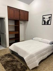 HOTEL GANADERO في لا دورادا: غرفة نوم بسرير كبير وخزانة خشبية