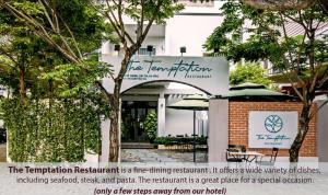 a sign in front of a building with trees at Hồng Châu Hotel in Da Nang