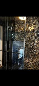 a bathroom with a glass shower with a wall of tiles at Badgers rest lodge in Kinlet