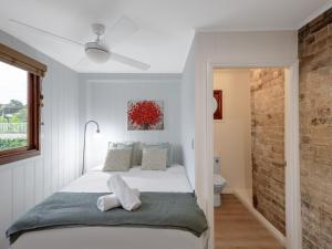 a white bedroom with a bed and a bathroom at Serene 3 Bedroom Inner City Retreat Highgate Hill in Brisbane