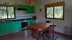 cocina con armarios verdes y mesa de madera en Liland en Capilla del Señor