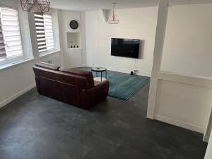 a living room with a couch and a flat screen tv at La petite dame de Maintenon in Maintenon +8 photos