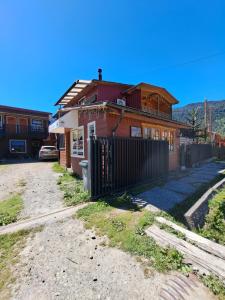 una casa con una valla delante de ella en Hostal Robinson, en Puerto Puyuhuapi