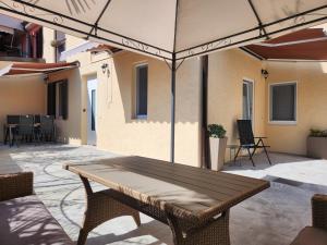 a patio with a table and chairs under an umbrella at Villa Marina Izola - Free Parking in Izola