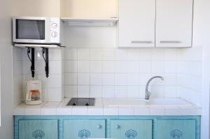 cocina con armarios azules y microondas en Résidence Tropicale en Le Moule