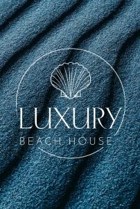 a logo for a beach house with a shell at Luxury Beach House in Torvaianica +58 photos