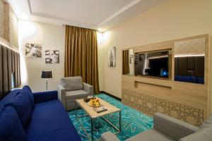 a living room with a blue couch and a tv at Taba Al Salam in Al Madinah
