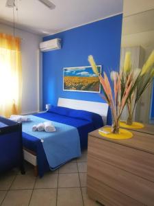 Dormitorio azul con cama y pared azul en Appartamento in riva al mare, en Trabia