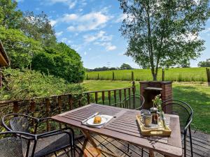 a wooden table with a plate of food sitting on a deck at 2 Bed in South Molton ISLVI in South Molton