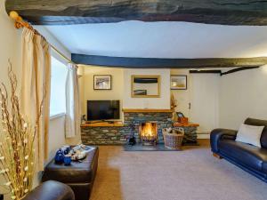 a living room with a couch and a fireplace at 3 Bed in Buttermere 82775 in Buttermere