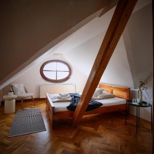 a attic room with a bed and a window at Penzion Pivovar Volt in Jablonec nad Nisou