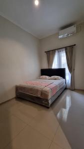 a bedroom with a bed in a room with a window at Villa Estate 43 New in Batu