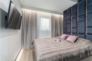 a bedroom with a large bed with pink pillows at Premium House in Rzeszów