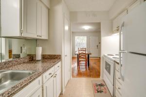 a kitchen with white cabinets and a table in it at Walkable Dallas Condo about 3 Mi to Downtown! in Dallas