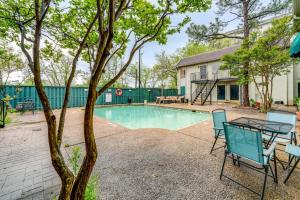 a patio with a table and chairs next to a pool at 3 Mi to Downtown Dallas Condo with Pool Access! in Dallas