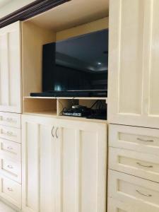 a entertainment center with a tv in a white cabinet at ROVIMAR in Angeles