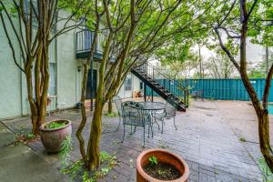 a patio with a table and chairs and trees at 3 Mi to Downtown Dallas Condo with Pool Access! in Dallas