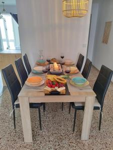 una mesa de madera con sillas y una mesa con comida. en Alicante El Campello DarioDoris, en El Campello