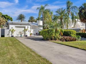 a white house with palm trees and a driveway at 5 Minute Walk to the Beach in Fort Lauderdale