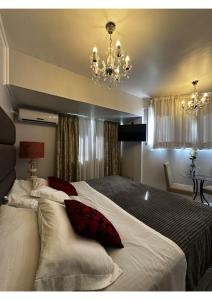 a bedroom with a large bed with white sheets and red pillows at Hotel Imigrantes in Bento Gonçalves +56 photos