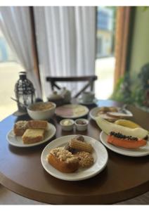 uma mesa com pratos de diferentes tipos de alimentos em Hotel Imigrantes em Bento Gonçalves