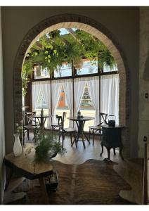 a room with tables and chairs and a large window at Hotel Imigrantes in Bento Gonçalves