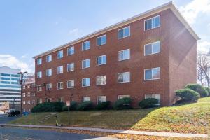 a large red brick building on the side of a street at Crystal City Boutique Flats 2BR - Free Parking 204 in Arlington